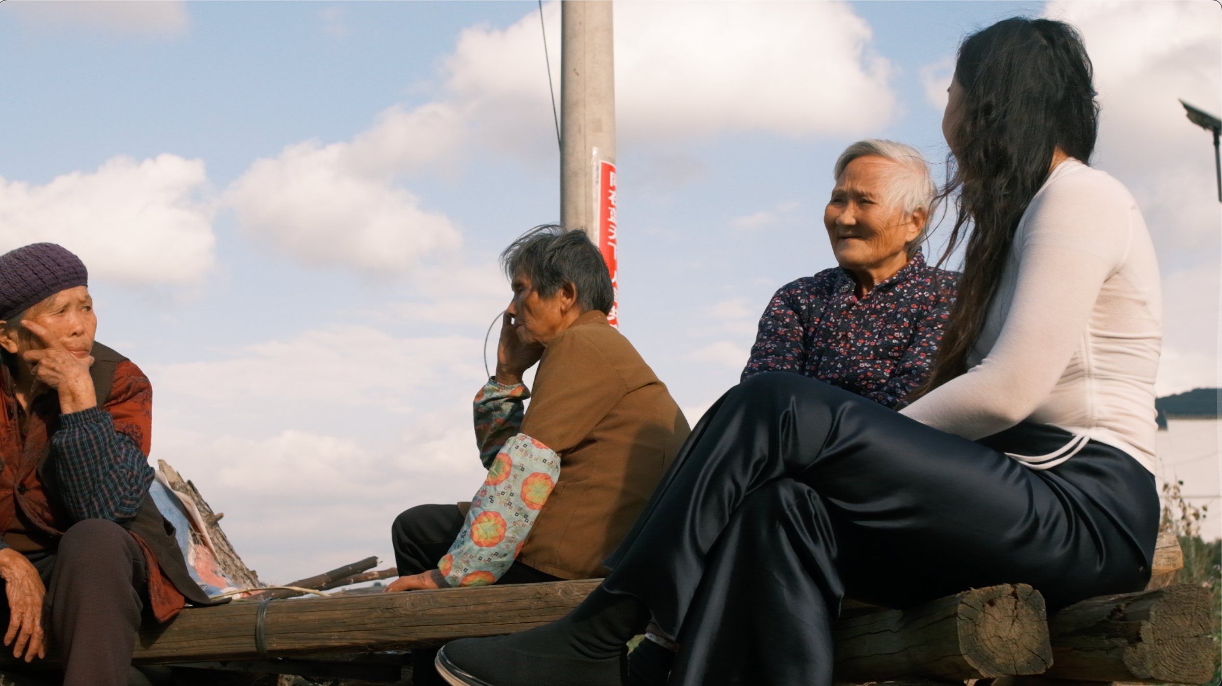 Xu sits with Grandma He, the last natural heir of Nüshu, and her two friends next to her home in Jiangyong. Still from Xu’s documentary film, “Outside Women’s Café (2023)”. Image courtesy of the artist.