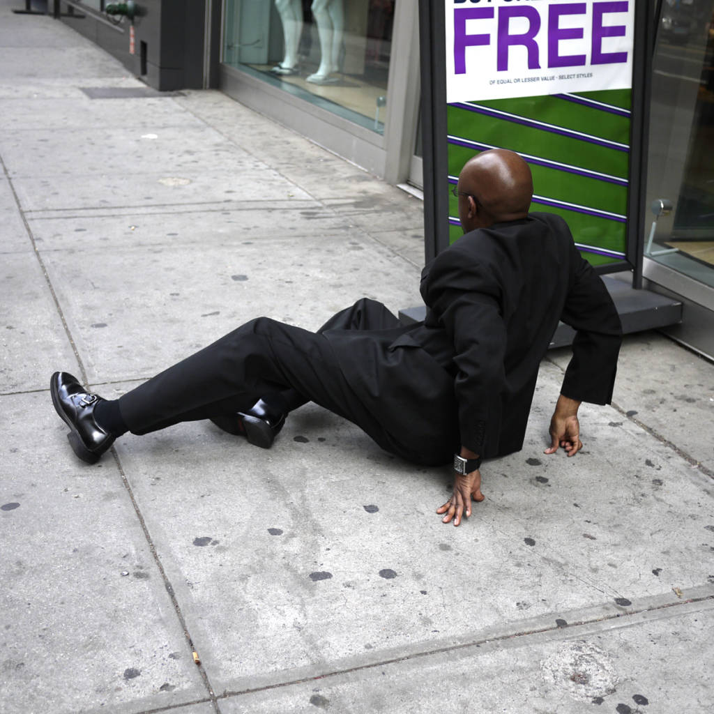 man in suit fallen on sidewalk