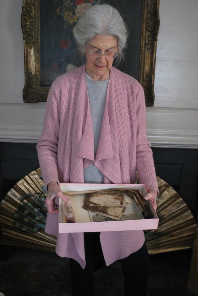 Connie Congdon holds a box filled with five artifacts a mason found in the chimney of her Nantucket home: 19th-century letters; a man's shirt collar; a pipe; a laudanum bottle; and a plaster phallus.