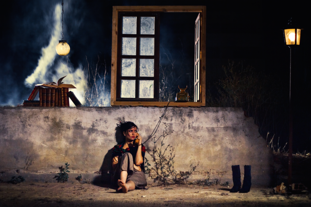 Woman sitting against a wall on the phone