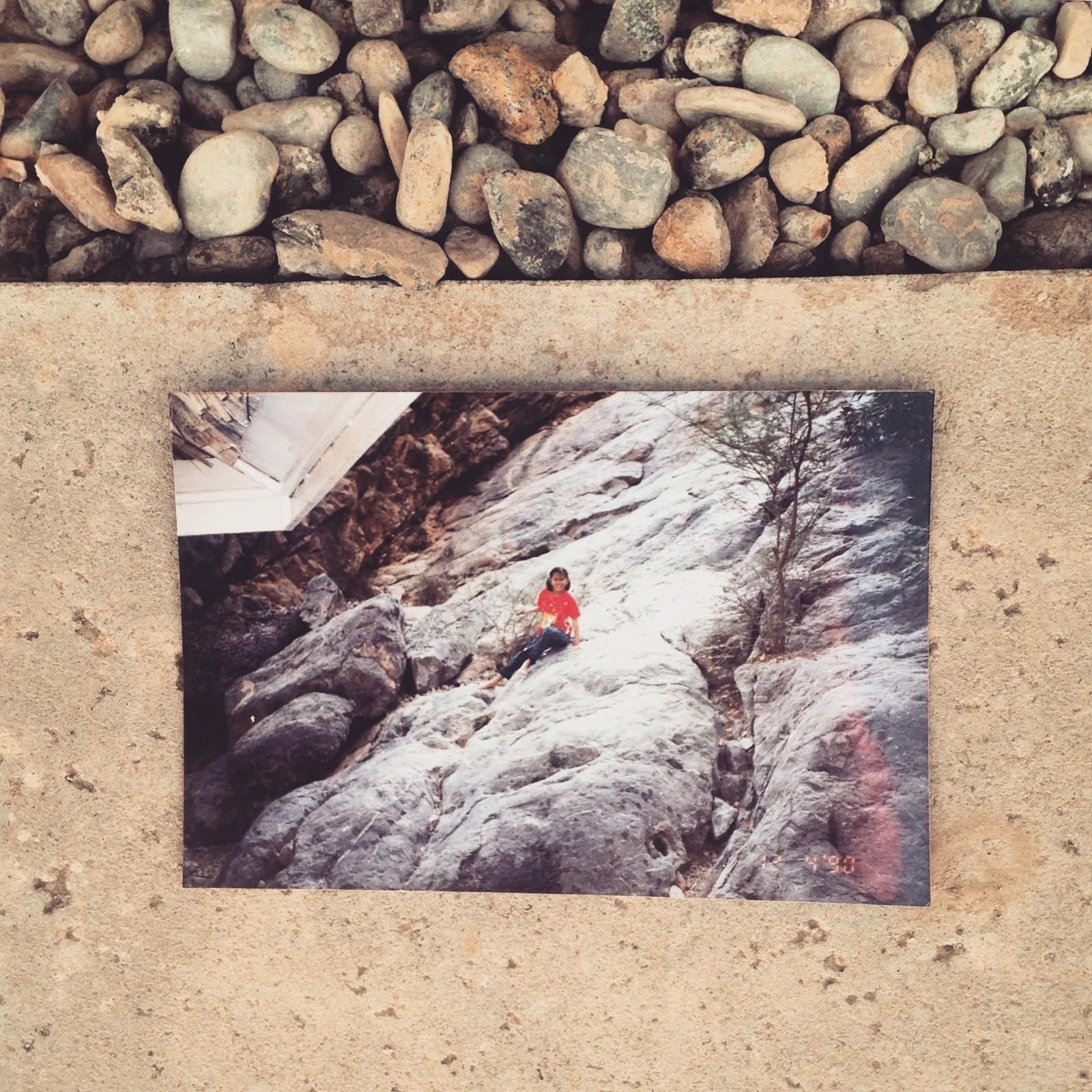 Image of a photograph featuring a girl lying on top of rocks.