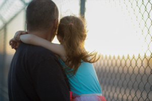 Man holding a girl in his arms, up close.