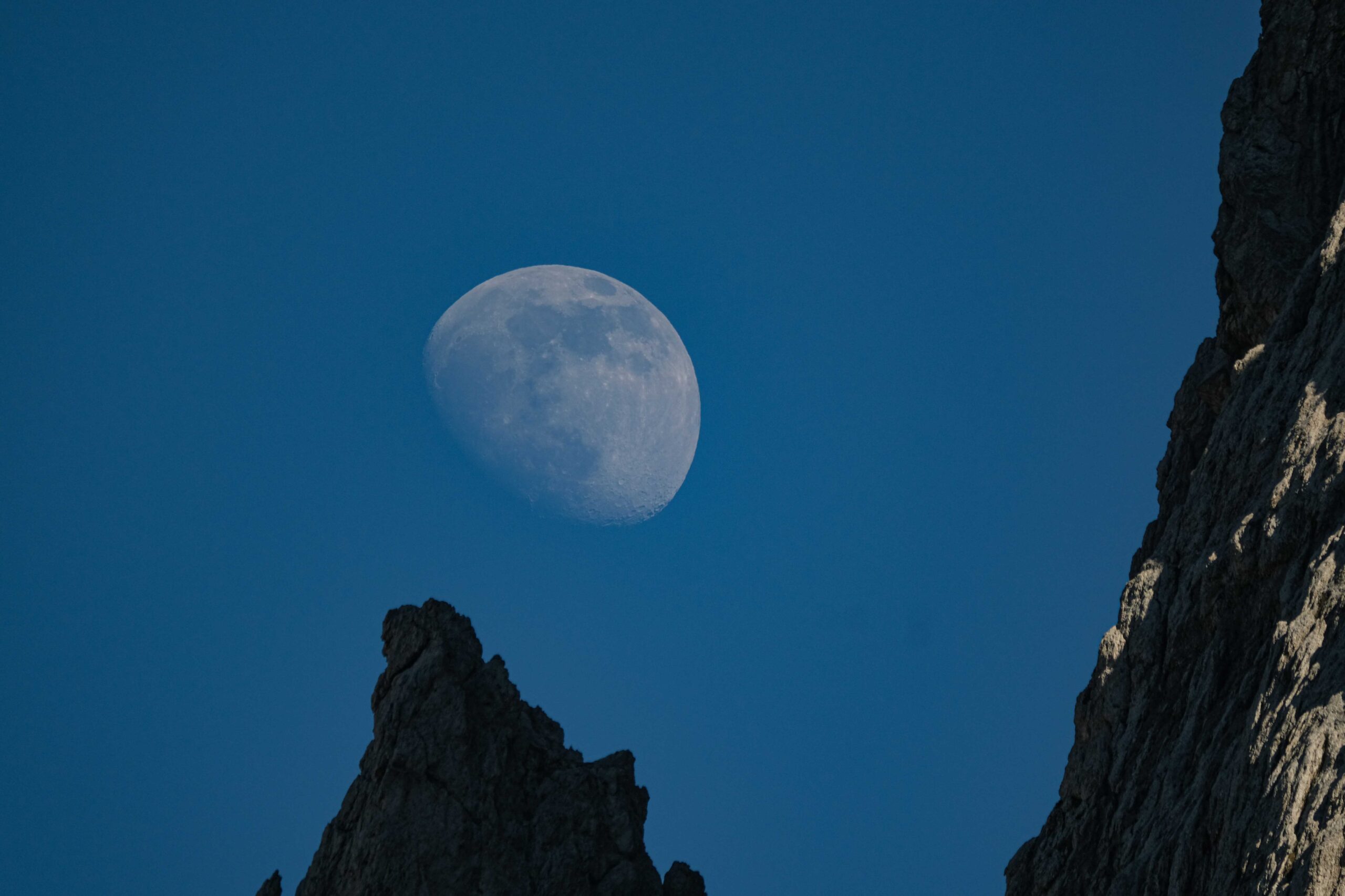 A waxing moon over rocky hills