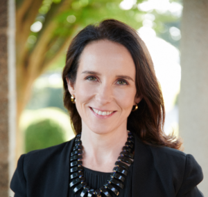 Meghan O'Rourke's headshot: white woman in a black shirt and blazer against a background of trees.