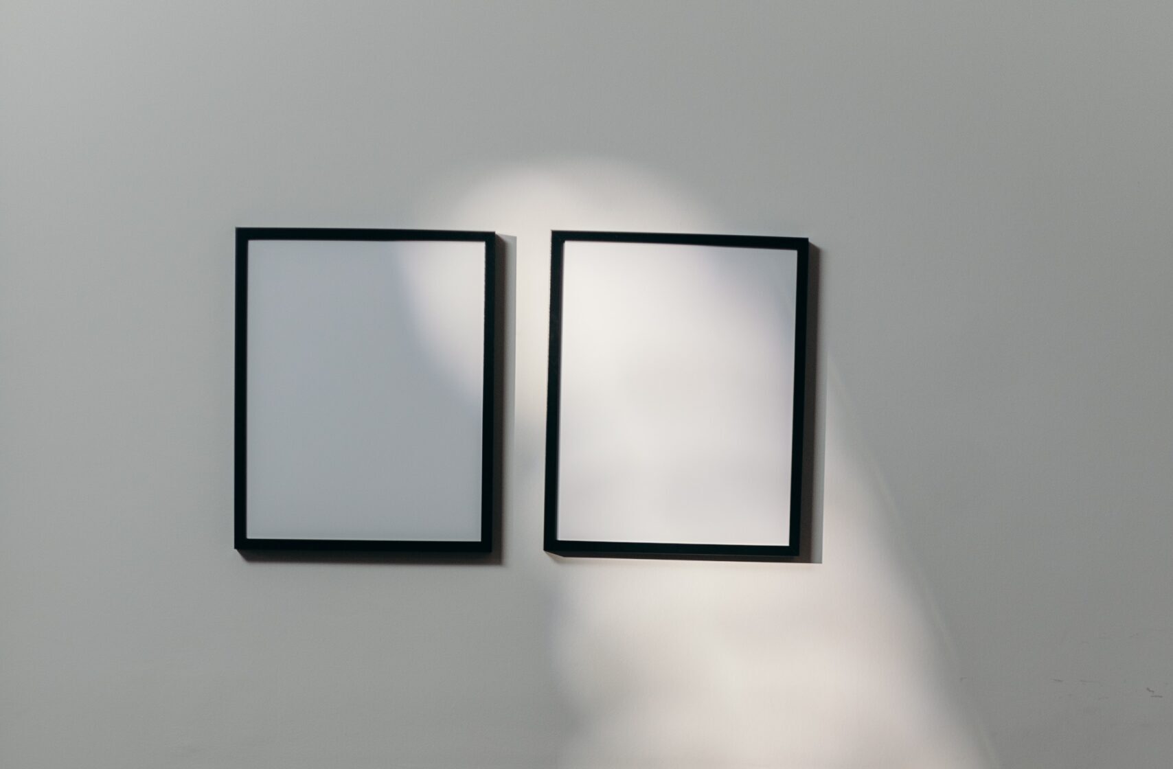 Image of two blank canvases on a white wall