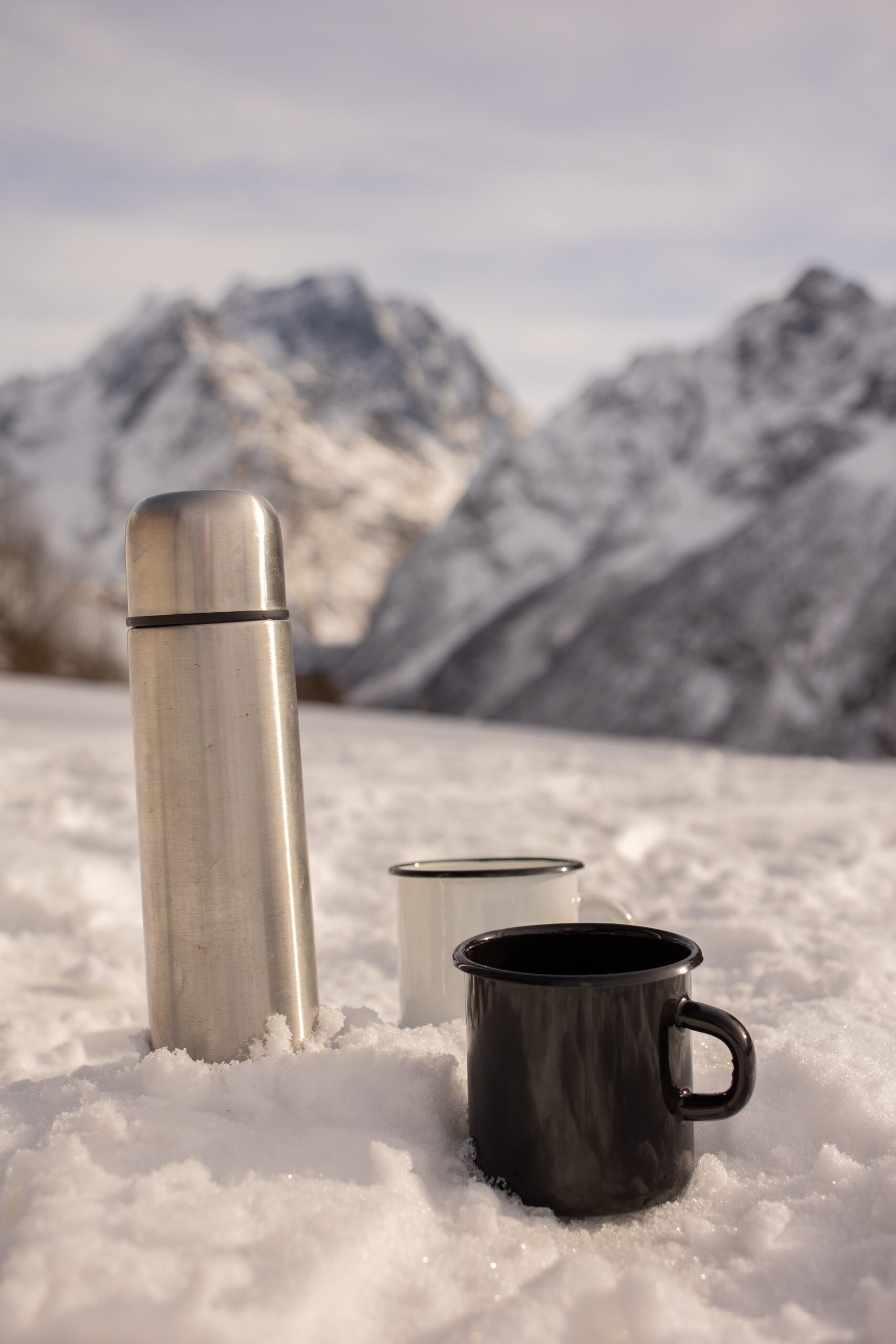 Thermos with a hot drink on mountain waterfall Stock Photo by