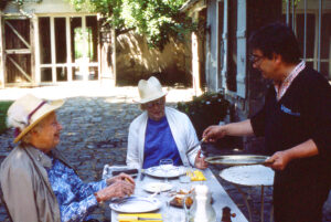 Two elderly women eating outdoors.
