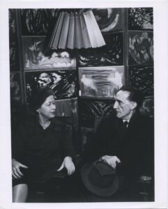 Images of Marcel and Teeny Duchamp. Black and white. Paintings in the background.