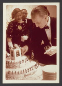 Marcel Duchamp cutting into a cake, back and white photo.