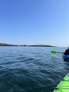 South Bristol, Maine. Pictured is a large body of water with small waves. Blue skies are above and land can be seen in the distance.