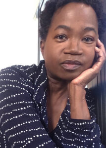 JoAnne McFarland's headshot: Black woman wearing a navy shirt with rows of white dots.