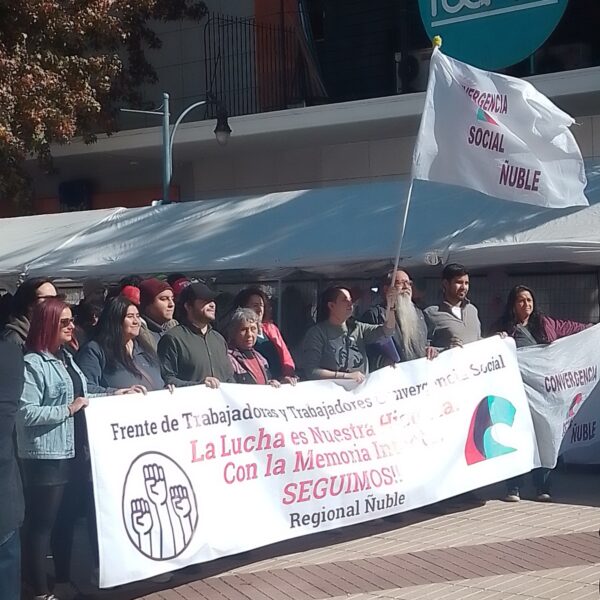 Photo of workers protesting at a strike, holding a sign with the name of their union