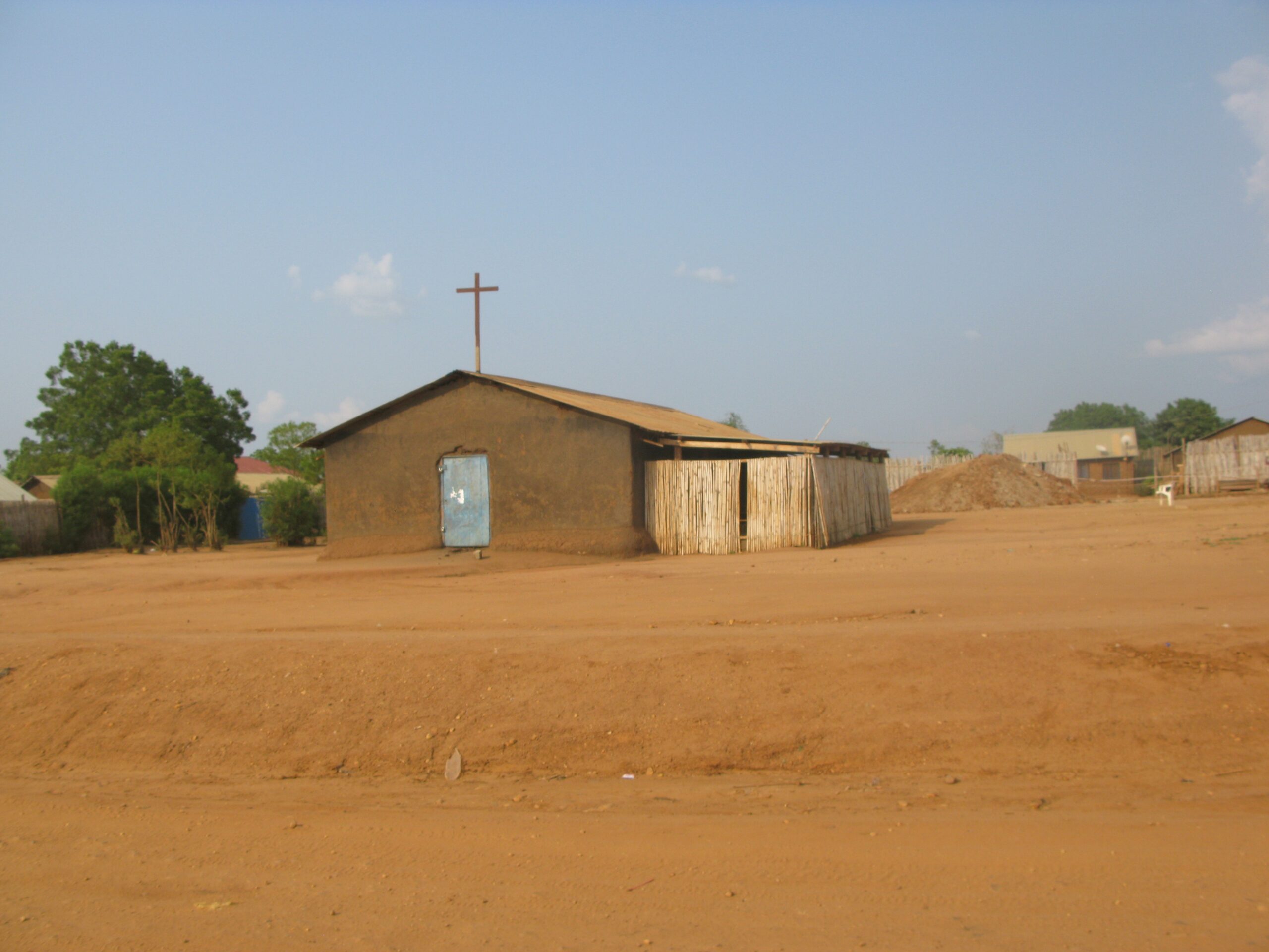 A church squats on an orange desert landscape.