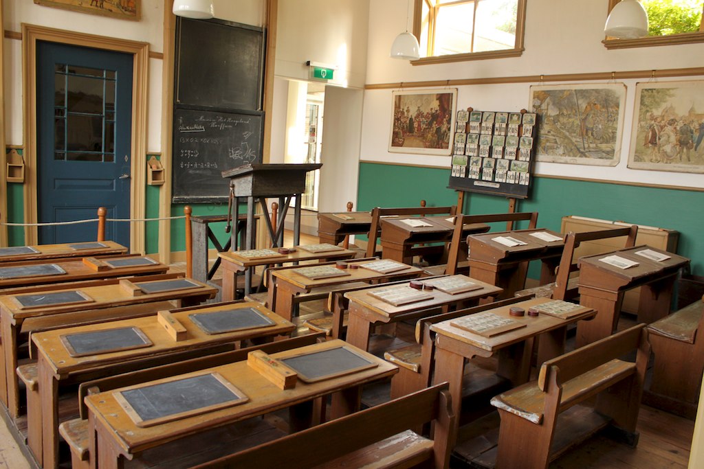 image of old desks lined up facing a blackboard