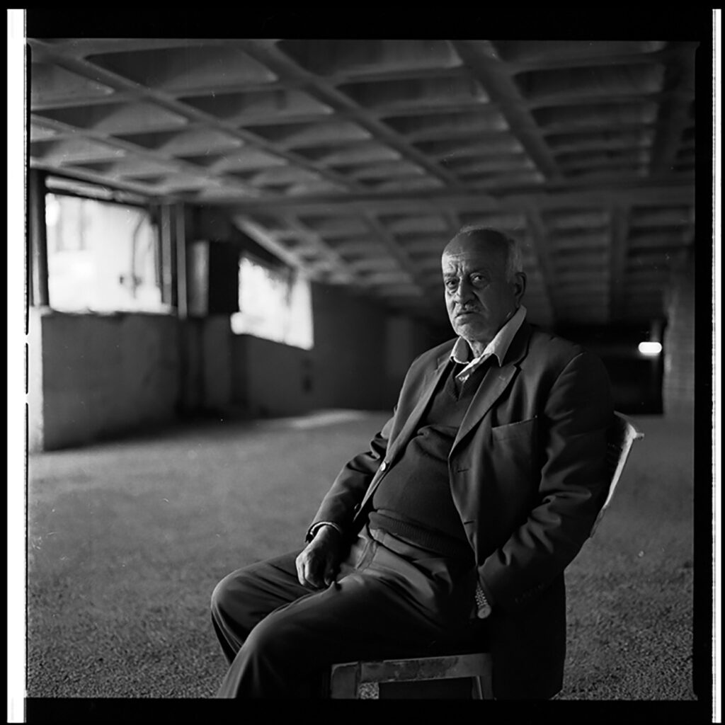 Man looks solemn in an open concrete building