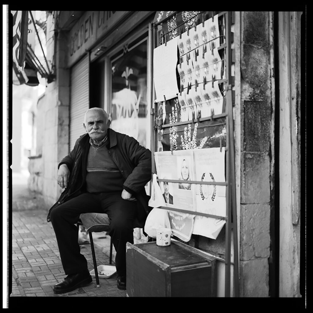 Man sits in front of storefront