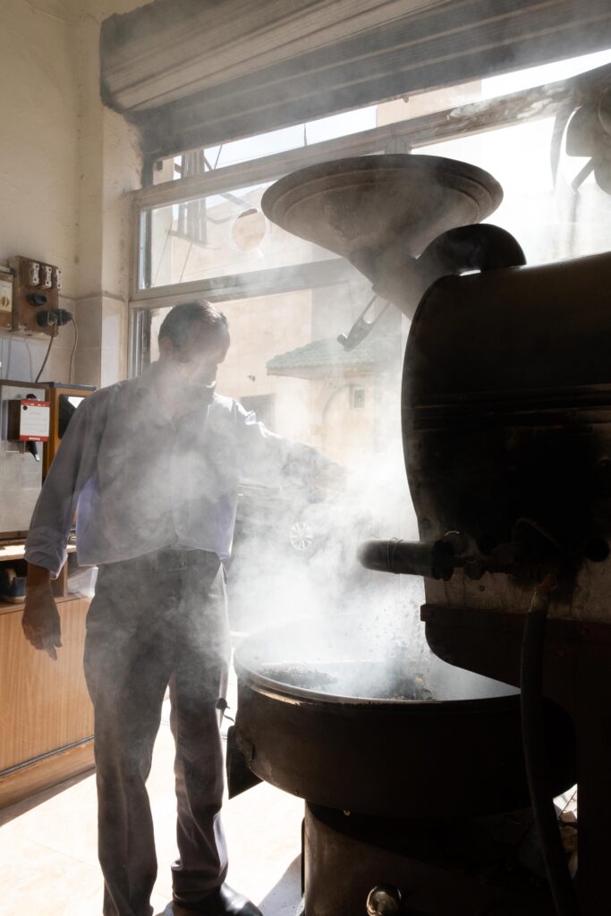 Man walks past a café’s outdoor seating in Jabal Al-Lweibdeh.