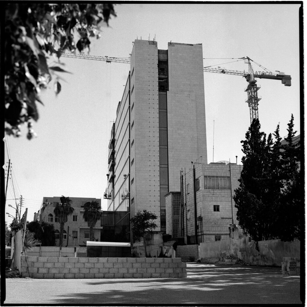 A crane looms behind a tall building
