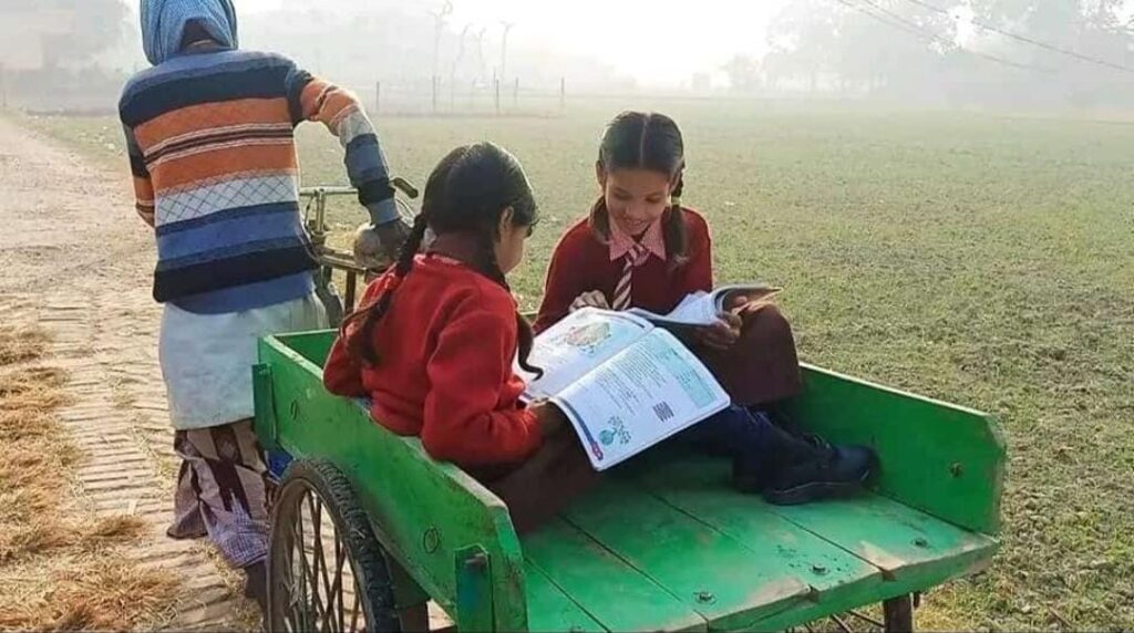 Two Sisters reading in a wheelbarrow