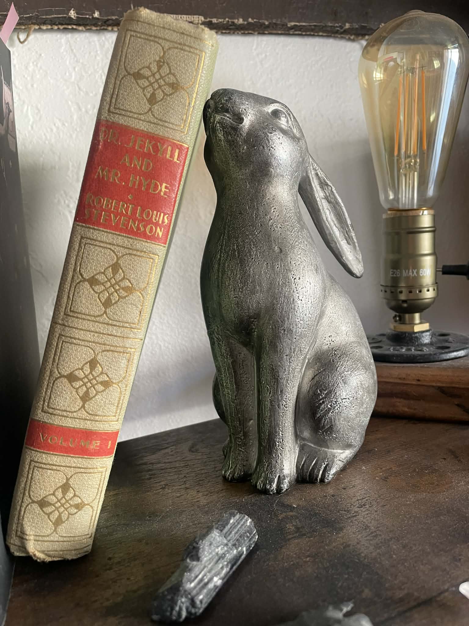 A sculpture bunny leaning against a book