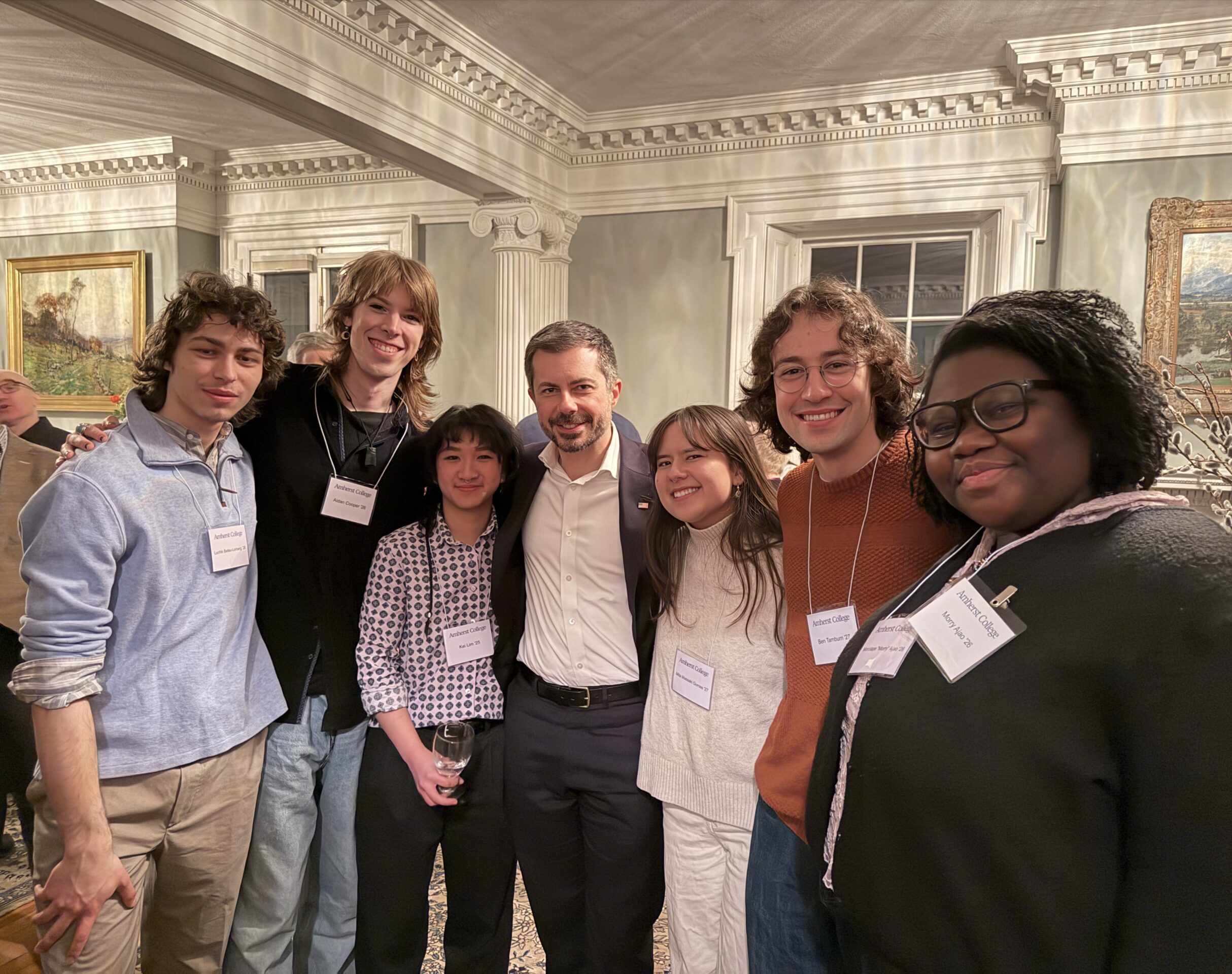 Seven people pose for a group photo inside a parlor.